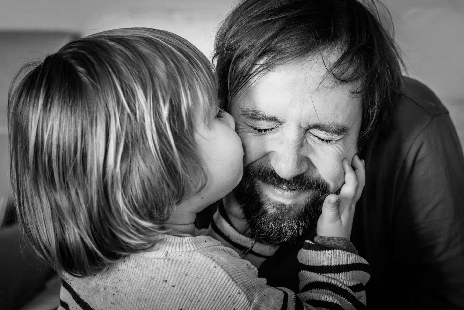 Das Kind küsst den Vater auf die Wange