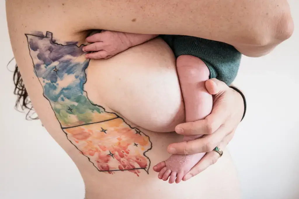 Mutter hält Neugeborenes im Arm – inniger Moment nach der Geburt, authentische Babyfotografie in Dortmund.